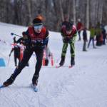 Homers Garrett Briscoe tucks for a downhill, closely pursued by Colonys Clayton Steer, during the first leg of the boys 4x5-kilometer relay at the ASAA State Nordic Ski Championships at Kincaid Park in Anchorage, Alaska, on Saturday, Feb. 25, 2023. (Jake Dye/Peninsula Clarion)