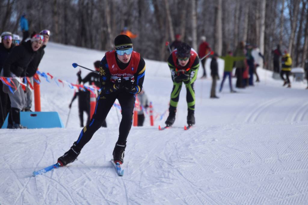 Homers Garrett Briscoe tucks for a downhill, closely pursued by Colonys Clayton Steer, during the first leg of the boys 4x5-kilometer relay at the ASAA State Nordic Ski Championships at Kincaid Park in Anchorage, Alaska, on Saturday, Feb. 25, 2023. (Jake Dye/Peninsula Clarion)