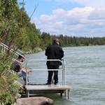 A fisher holds a reel on the Kenai River near Soldotna on June 30, 2021. (Photo by Ashlyn OHara/Peninsula Clarion)