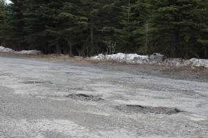 Potholes are seen on Wildwood Drive on Thursday, April 22, 2021, in Kenai, Alaska. (Ashlyn OHara/Peninsula Clarion)