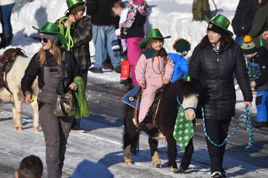 A child rides a pony as the 32nd annual Sweeneys St. Patricks Day Parade proceeds down Fireweed Street in Soldotna, Alaska on Friday, March 17, 2023. (Jake Dye/Peninsula Clarion)