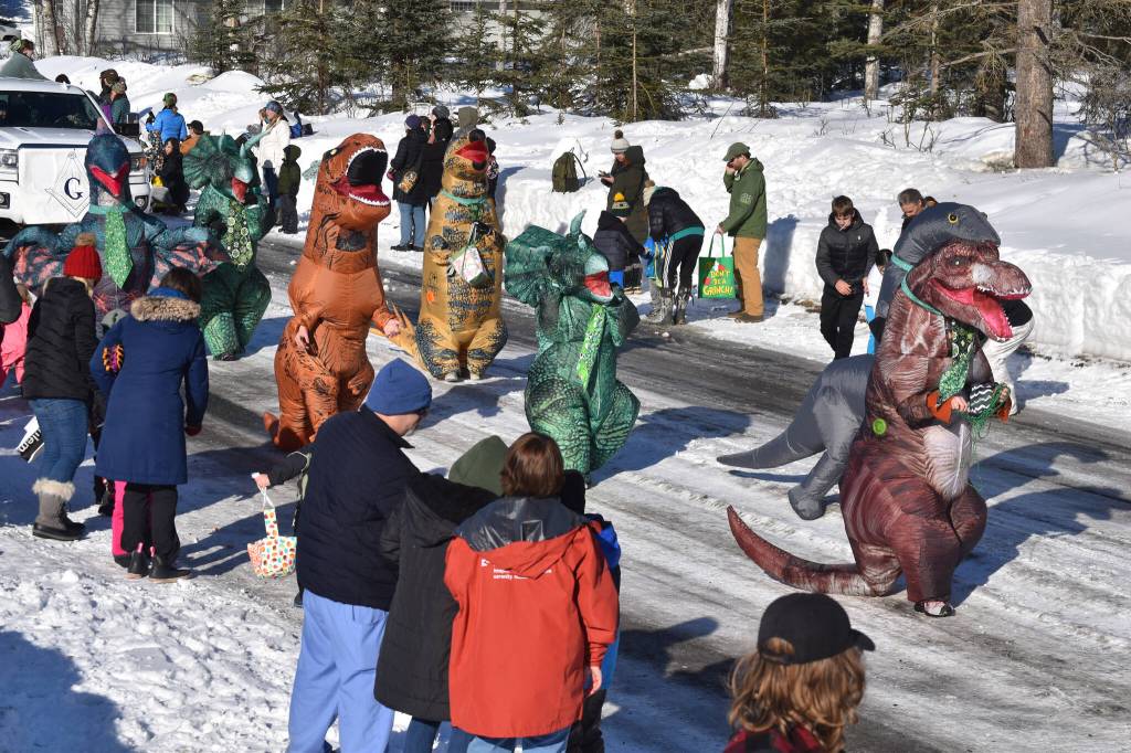 A herd of dinosaurs pass out candy as the 32nd annual Sweeneys St. Patricks Day Parade proceeds down Fireweed Street in Soldotna, Alaska on Friday, March 17, 2023. (Jake Dye/Peninsula Clarion)