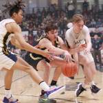 Ninilchiks Jaylin Scott and Peyton Edens and Aqquilluk Hank of Tikigaq battle for the ball in the Class 2A boys state championship game Saturday, March 18, 2023, at the Alaska Airlines Center in Anchorage, Alaska. (Photo courtesy of Robin Moore)