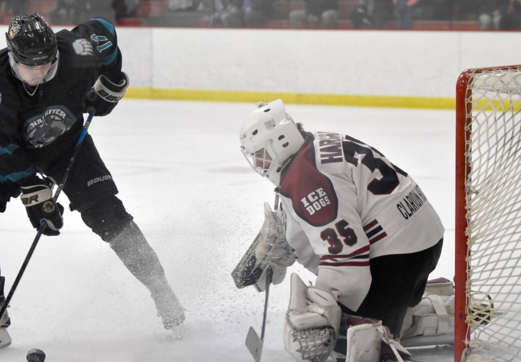 Fairbanks Ice Dogs goalie Kayden Hargraves makes a save on Kenai River Brown Bears forward Owen Hanson on Saturday, March 25, 2023, at the Soldotna Regional Sports Complex in Soldotna, Alaska. (Photo by Jeff Helminiak/Peninsula Clarion)