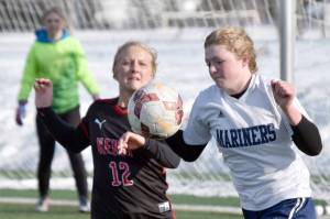 Kenai Central's Kate Wisnewski and Homer's Talia Weisser battle for the ball Thursday, April 6, 2023, at Ed Hollier Field at Kenai Central High School in Kenai, Alaska. (Photo by Jeff Helminiak/Peninsula Clarion)