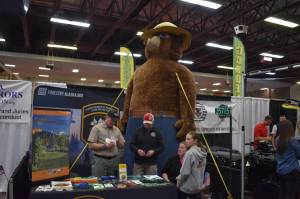 Alaska Division of Forestry & Fire Protection staff stand with Smokey Bear at the 43rd Annual Home Show hosted by the Kenai Peninsula Builders Association on Sunday, April 23, 2023, at the Soldotna Regional Sports Complex in Soldotna, Alaska. (Jake Dye/Peninsula Clarion)