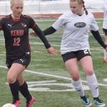 Kenai Central's Kate Wisnewski shields the ball from Nikiski's Wynter Yeager on Tuesday, April 25, 2023, at Ed Hollier Field at Kenai Central High School in Kenai, Alaska. (Photo by Jeff Helminiak/Peninsula Clarion)