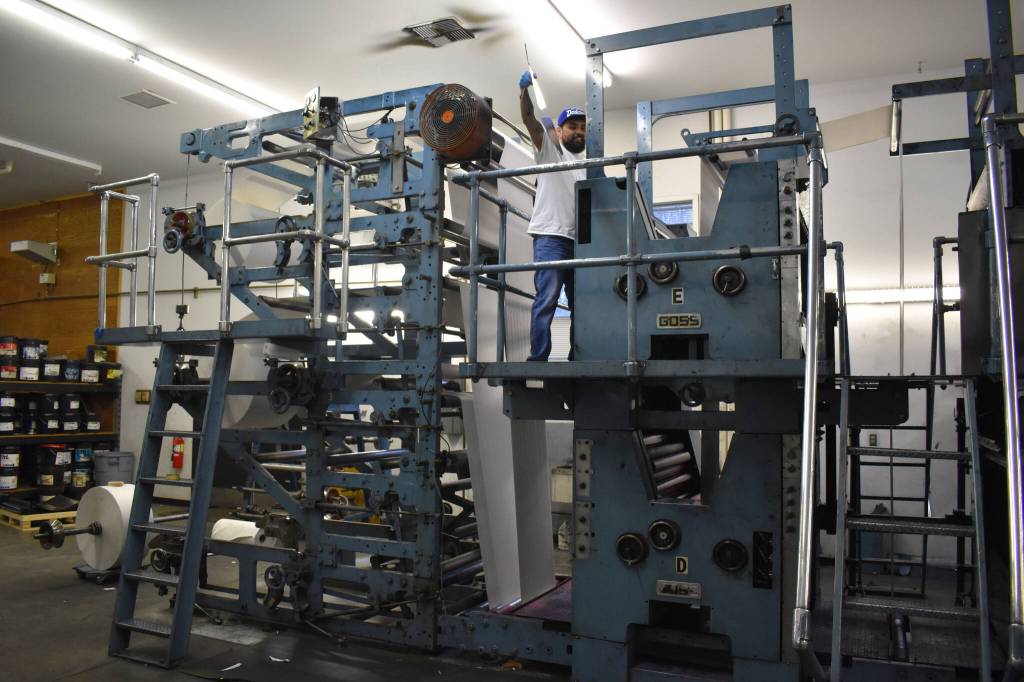 Eric Trevino pulls plates from the press on Monday, April 24, 2023, in the Peninsula Clarion pressroom in Kenai, Alaska. (Jake Dye/Peninsula Clarion)