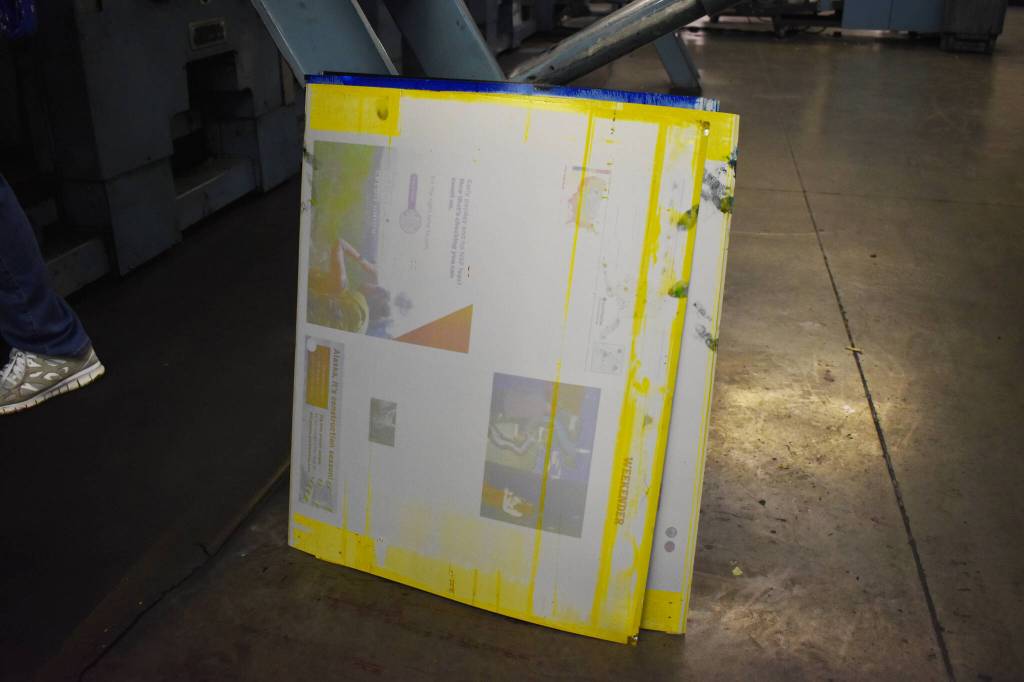 Used plates, still covered in ink, are removed from the press on Monday, April 24, 2023, in the Peninsula Clarion pressroom in Kenai, Alaska. (Jake Dye/Peninsula Clarion)