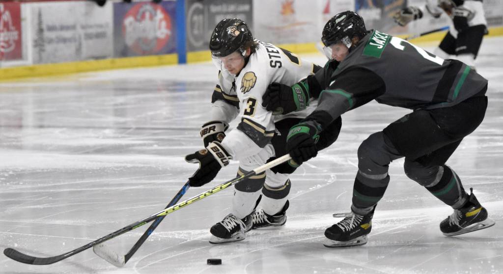 Nick Stevens of the Kenai River Brown Bears and Beau Janzig of the Minnesota Wilderness battle for the puck Friday, April 28, 2023, at the Soldotna Regional Sports Complex in Soldotna, Alaska. (Photo by Jeff Helminiak/Peninsula Clarion)