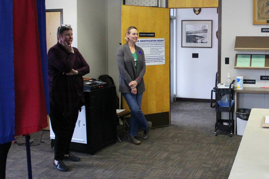 Seward City Clerk Brenda Ballou (left) and poll worker Vanessa Verhey stand near a ballot tabulator during a special election on Tuesday, May 2, 2023, in Seward City Hall in Seward, Alaska. (Ashlyn OHara/Peninsula Clarion)