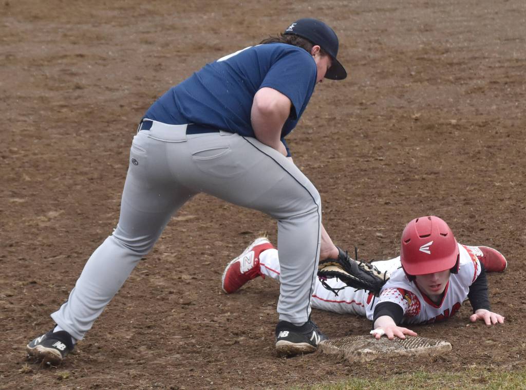Kenai Centrals Daniel Steffensen slides under the tag of Soldotna first baseman Evan Appelhans on Tuesday, May 2, 2023, at the Kenai Little League fields in Kenai, Alaska. (Photo by Jeff Helminiak/Peninsula Clarion)