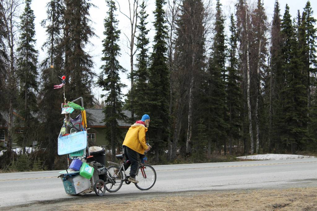 White Rainbow rides his bike at a gas station on Wednesday, May 3, 2023 near Sterling, Alaska. (Ashlyn OHara/Peninsula Clarion)
