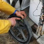 White Rainbow examines a flat tire on his bike at a gas station on Wednesday, May 3, 2023 near Sterling, Alaska. (Ashlyn OHara/Peninsula Clarion)