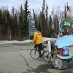 White Rainbow rides his bike at a gas station on Wednesday, May 3, 2023 near Sterling, Alaska. (Ashlyn OHara/Peninsula Clarion)