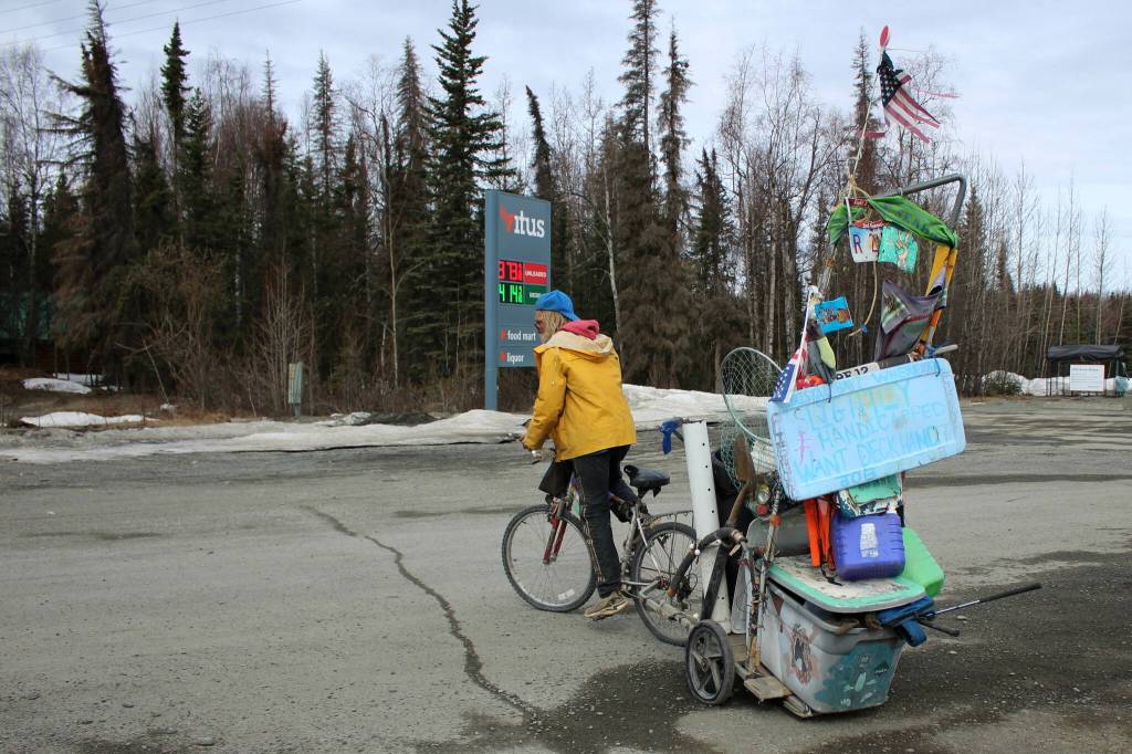 White Rainbow rides his bike at a gas station on Wednesday, May 3, 2023 near Sterling, Alaska. (Ashlyn OHara/Peninsula Clarion)