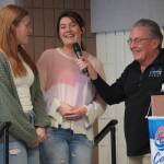 Hope Hillyer and Grace Henry, of Cook Inlet Academy, are introduced by Merrill Sikorski at the Caring for the Kenai Awards Celebration held during a Joint Chamber Luncheon on Wednesday, May 3, 2023, at the Soldotna Regional Sports Complex in Soldotna, Alaska. (Jake Dye/Peninsula Clarion)