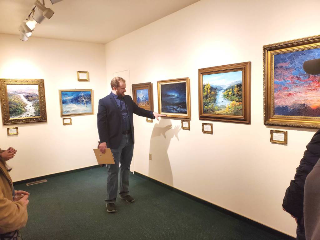 Curator Barnabas Firth tells stories of artworks by Norman Lowell to attendees of the invitational gathering on Saturday, April 29, 2023 at the Norman Lowell Art Gallery in Anchor Point, Alaska. Photo by Delcenia Cosman