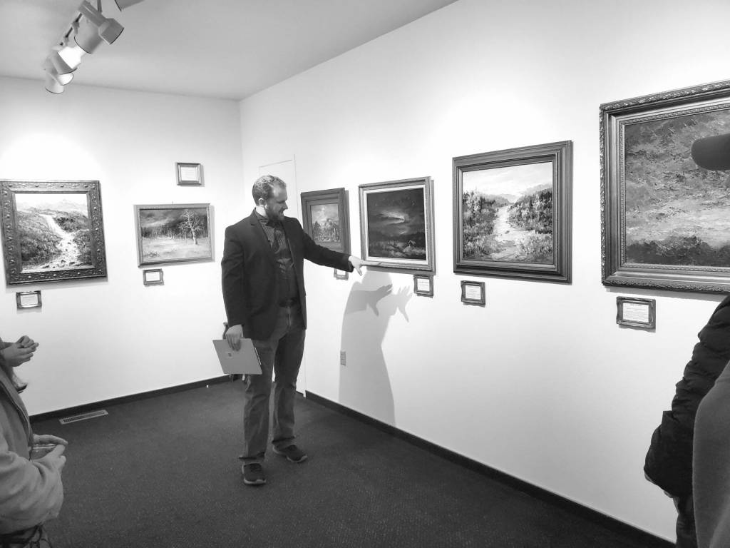 Curator Barnabas Firth tells stories of artworks by Norman Lowell to attendees of the invitational gathering on Saturday at the Norman Lowell Art Gallery in Anchor Point. Photo by Delcenia Cosman
