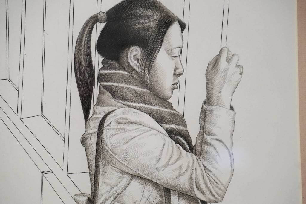 A drawing of a woman and her camera by artist Nathan Perry hangs as part of Elaborate Expressions at the Kenai Art Center in Kenai, Alaska on May 3, 2023. (Jake Dye/Peninsula Clarion)