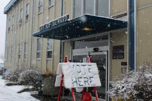 Snow falls on a "vote here" sign outside of Seward City Hall on Tuesday, May 2, 2023 in Seward, Alaska. Residents voted in a special election to determine whether or not to sell the citys electric utility and to change the citys residency requirements for city manager. (Ashlyn OHara/Peninsula Clarion)
