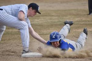 Kodiak's Robert Anderson slides under the tag of Soldotna's Wyatt Gagnon on Friday, May 5, 2023, at the Soldotna Little League fields in Soldotna, Alaska. (Photo by Jeff Helminiak/Peninsula Clarion)
