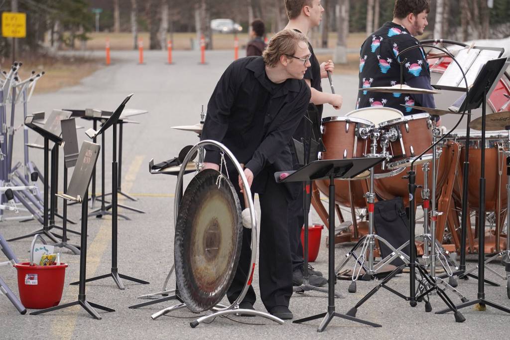 Kage Adkins strikes a gong during Pops in the Parking Lot at Kenai Central High School in Kenai, Alaska, on Thursday, May 4, 2023. (Jake Dye/Peninsula Clarion)