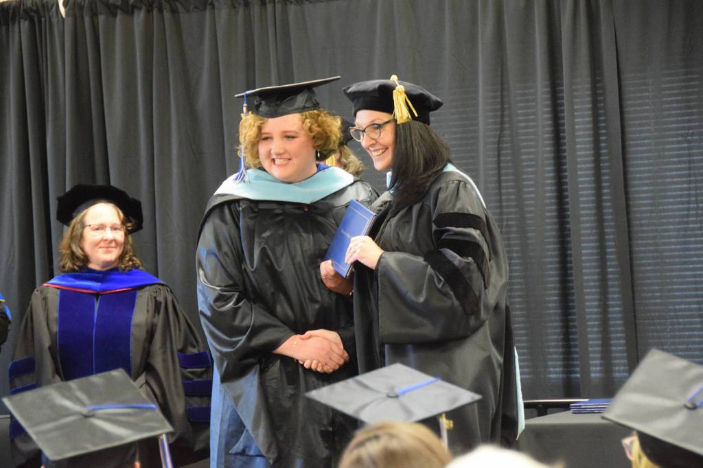 University of Alaska Southeasts Dr. Christine Ermold (right) presents Rachel Ostler with her diploma and masters hood during the 2023 KBC Commencement on Wednesday, May 10, 2023 in Homer, Alaska. Ostler completed her Master of Arts degree in Education through UAS. (Photo by Delcenia Cosman/Homer News)