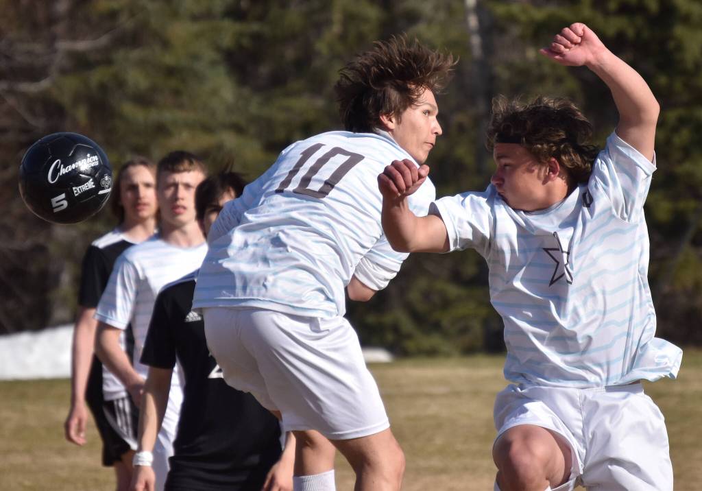 Soldotnas Daniel Heath and Johnny Wardas try to head the ball in Nikiskis goal Friday, May 12, 2023, at Nikiski High School in Nikiski, Alaska. (Photo by Jeff Helminiak/Peninsula Clarion)