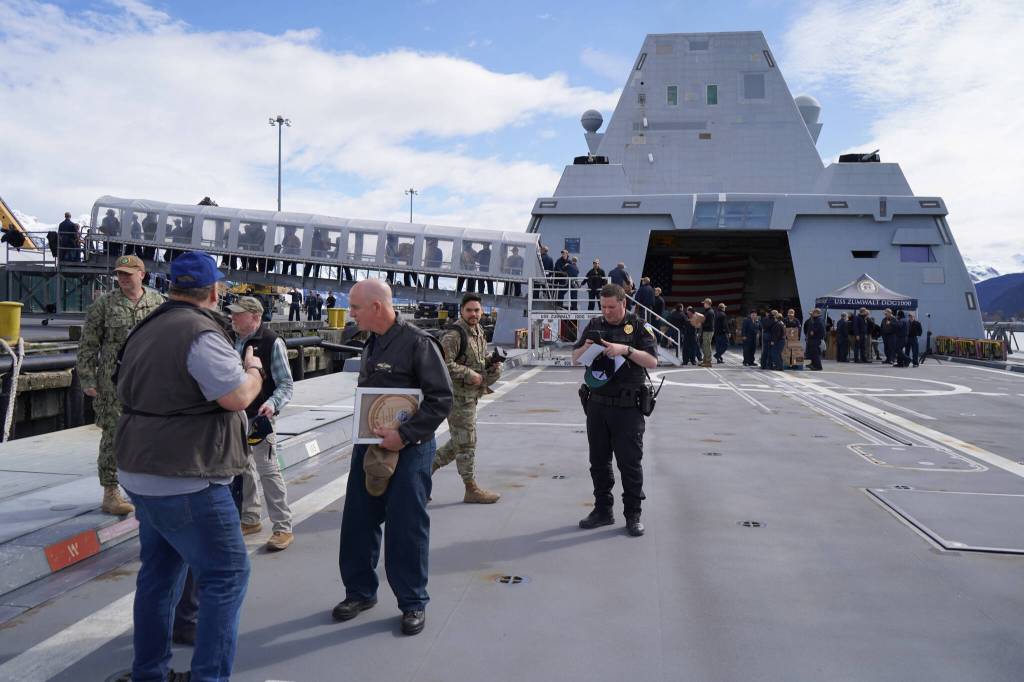 Visitors to the USS Zumwalt chat with Capt. Matthew Hall on the flight deck of the ship in Seward, Alaska, on Friday, May 15, 2023. (Jake Dye/Peninsula Clarion)