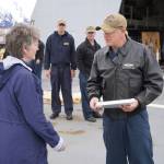 Seward Mayor Sue McClure presents Capt. Matthew Hall of the USS Zumwalt with a plaque commemorating their first voyage to the port on Friday, May 12, 2023, in Seward, Alaska. (Jake Dye/Peninsula Clarion)