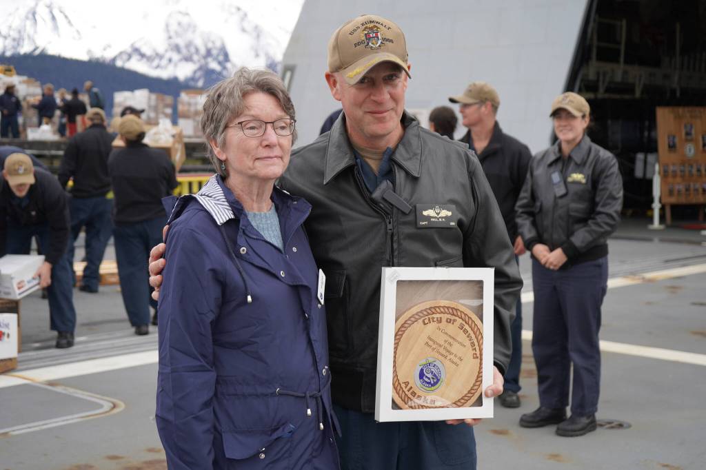 Seward Mayor Sue McClure presents Capt. Matthew Hall of the USS Zumwalt with a plaque commemorating their first voyage to the port on Friday, May 12, 2023, in Seward, Alaska. (Jake Dye/Peninsula Clarion)