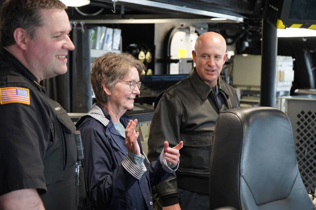 Deputy Police Chief Karl Schaefermeyer and Seward Mayor Sue McClure join Captain Matthew Hall on the bridge of the USS Zumwalt on Friday, May 12, 2023, in Seward, Alaska. (Jake Dye/Peninsula Clarion)