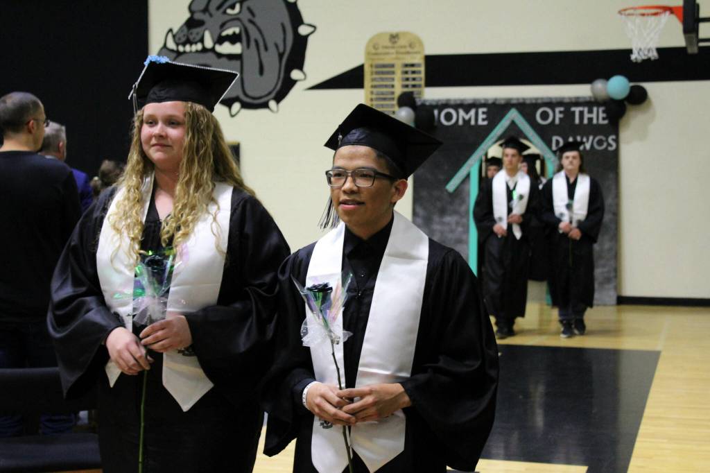 Nikiski Middle/High School graduates Shelby OBrien (left) and Nathan Bourdukofsky (right) file into the gymnasium during their graduation ceremony on Tuesday, May 16, 2023, in Nikiski, Alaska. (Ashlyn OHara/Peninsula Clarion)