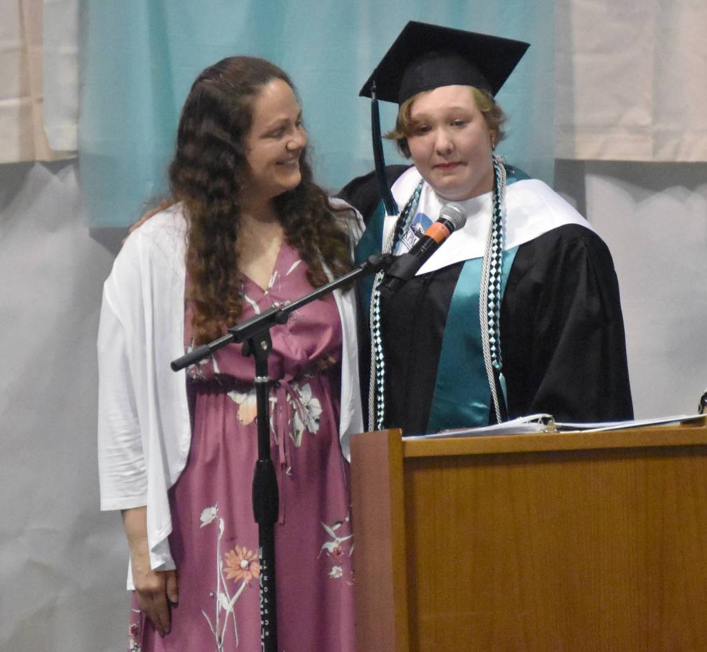 River City Academy graduate Hannah Crabtree gives an address with her mother, Annie Crabtree, by her side. Hannah won so many awards and scholarships that she was directed to take a seat onstage instead of continually returning to her seat. I owe everything to my mom, Hannah said. All those fancy awards was because she helped me get there. (Photo by Jeff Helminiak/Peninsula Clarion)