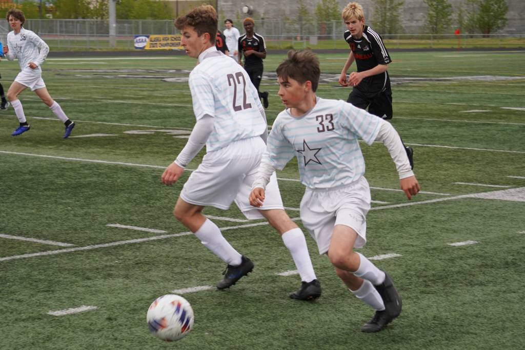 Soldotnas Lane Hillyer moves with the ball, defended by teammate Zachary Buckbee and pursued by Juneau-Douglas Owen Rumsey during the Division II Soccer State Championship on Saturday, May 27, 2023, at West Anchorage High School in Anchorage, Alaska. (Jake Dye/Peninsula Clarion)