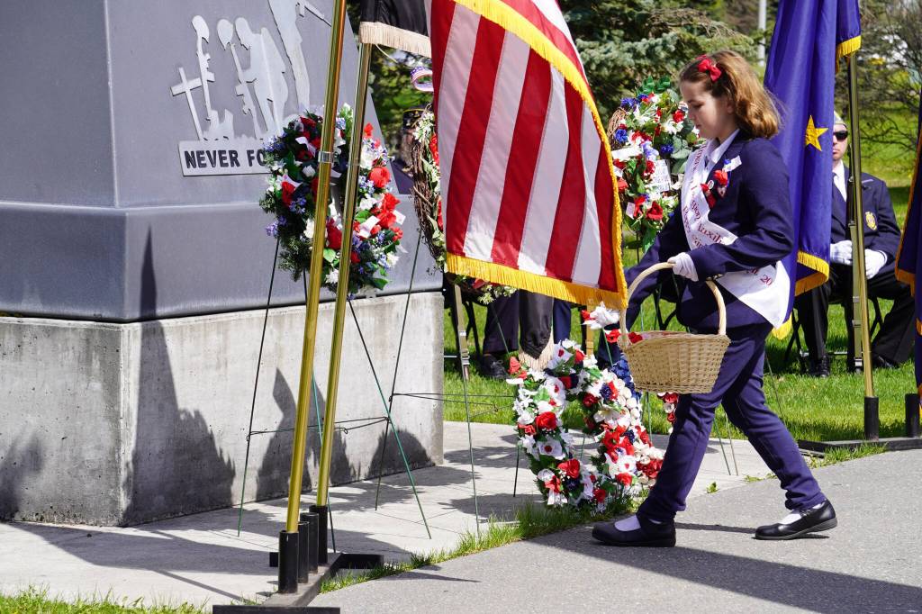 The American Legion Post 20 Poppy Girl distributes poppies during a Memorial Day ceremony on Monday, May 29, 2023, at Leif Hanson Memorial Park in Kenai, Alaska. (Jake Dye/Peninsula Clarion)