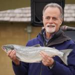 Kenai Peninsula Borough Mayor Peter Micciche holds up the first salmon of the season, caught and auctioned off at Return of the Reds on Saturday, June 3, 2023, at the Kenai City Dock in Kenai, Alaska. (Jake Dye/Peninsula Clarion)