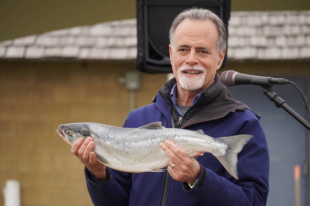 Kenai Peninsula Borough Mayor Peter Micciche holds up the first salmon of the season, caught and auctioned off at Return of the Reds on Saturday, June 3, 2023, at the Kenai City Dock in Kenai, Alaska. (Jake Dye/Peninsula Clarion)