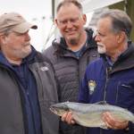 Auction winner Jim Butler, Angler Dave Chessik and auctioneer Peter Micciche stand together with the first sockeye of the season, sold for $58 a pound at Return of the Reds on Saturday, June 3, 2023, at the Kenai City Dock in Kenai, Alaska. (Jake Dye/Peninsula Clarion)