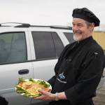 Chef Lastan Williams, of The Catch, stands with a salmon dish prepared for the Best Salmon Recipe competition at Return of the Reds on Saturday, June 3, 2023, at the Kenai City Dock in Kenai, Alaska. (Jake Dye/Peninsula Clarion)