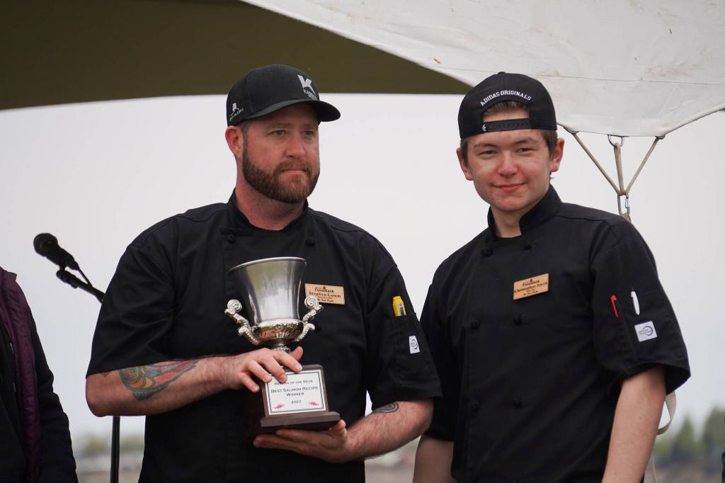 Kenai Peninsula Food Bank head chef Stephen Lamm and sous chef Christopher Smith stand with their trophy for winning the Return of the Reds Best Salmon Recipe competition on Saturday, June 3, 2023, at the Kenai City Dock in Kenai, Alaska. (Jake Dye/Peninsula Clarion)