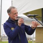 Kenai Peninsula Borough Mayor Peter Micciche kisses the first salmon of the season, caught and auctioned off at Return of the Reds on Saturday, June 3, 2023, at the Kenai City Dock in Kenai, Alaska. (Jake Dye/Peninsula Clarion)