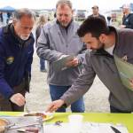 Judges Peter Micciche, Terry Eubank and Tyler Best sample a salmon dish prepared by chef Stephen Lamm of the Kenai Peninsula Food Bank at Return of the Reds on Saturday, June 3, 2023, at the Kenai City Dock in Kenai, Alaska. (Jake Dye/Peninsula Clarion)