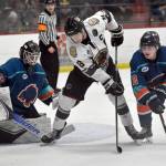 Kenai River Brown Bears forward Noah Holt battles Anchorage Wolverines defenseman Trent Powell in front of Wolverines goalie Eino Rissanen on Saturday, Nov. 19, 2022, at the Soldotna Regional Sports Complex in Soldotna, Alaska. Powell was born and raised in Soldotna. (Photo by Jeff Helminiak/Peninsula Clarion)