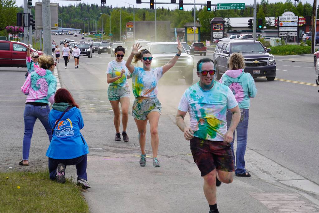 Participants are covered with colored powder during a color run held as part of during the Levitt AMP Soldotna Music Series on Wednesday, June 7, 2023, along the Sterling Highway in Soldotna, Alaska. (Jake Dye/Peninsula Clarion)