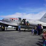 A long line of attendees wait to tour the inside a large plane displayed at the Kenai Peninsula Air Fair on Saturday, June 10, 2023, at the Kenai Municipal Airport in Kenai, Alaska. (Jake Dye/Peninsula Clarion)