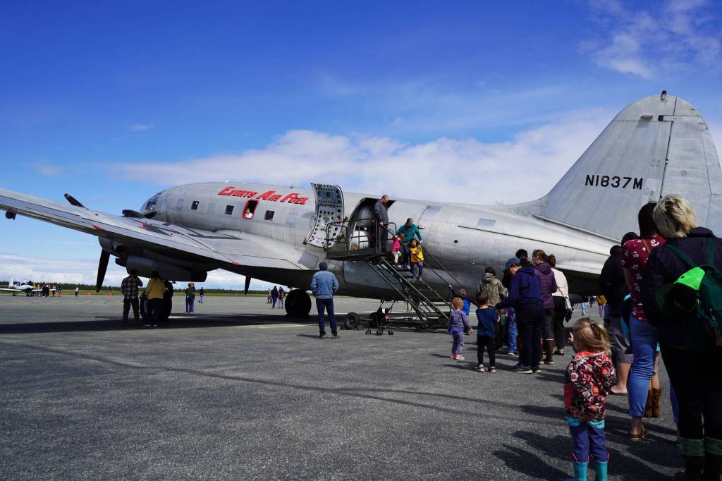 A long line of attendees wait to tour the inside a large plane displayed at the Kenai Peninsula Air Fair on Saturday, June 10, 2023, at the Kenai Municipal Airport in Kenai, Alaska. (Jake Dye/Peninsula Clarion)