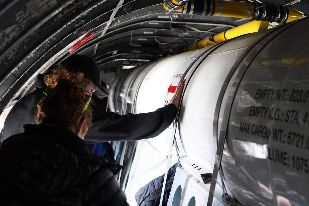 Attendees move down a passageway inside a large plane displayed at the Kenai Peninsula Air Fair on Saturday, June 10, 2023, at the Kenai Municipal Airport in Kenai, Alaska. (Jake Dye/Peninsula Clarion)