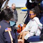 A representative of LifeMed Alaska answers questions from a young attendee at the Kenai Peninsula Air Fair on Saturday, June 10, 2023, at the Kenai Municipal Airport in Kenai, Alaska. (Jake Dye/Peninsula Clarion)